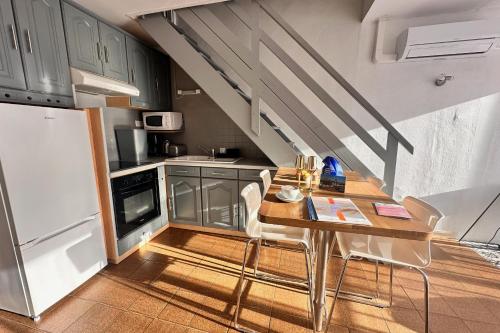una cocina con una mesa con sillas y una escalera en Le saint Pierre, en Le Grau-du-Roi