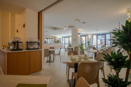 ein Restaurant mit Tischen und Stühlen und einer Theke in der Unterkunft Hotel Tognon in Grado