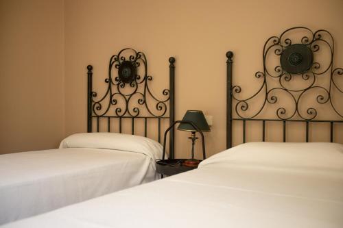 Dos camas en una habitación con sábanas blancas. en BAIONA PRIMERA LINEA PLAYA 6 HUESPED CON GARAJE, en Baiona