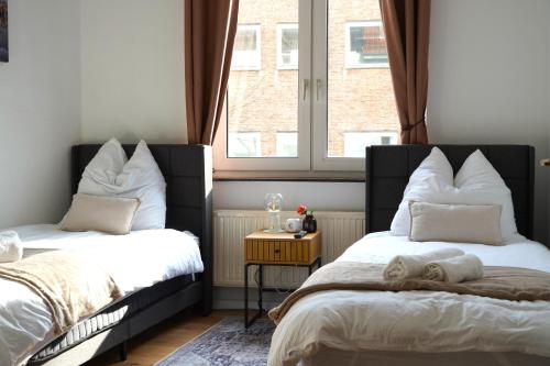 sypialnia z 2 łóżkami i oknem w obiekcie Timeless Apartment II Bremen-Neustadt w Bremie
