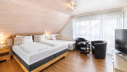 1 Schlafzimmer mit 2 Betten und einem Flachbild-TV in der Unterkunft Hotel Garni Sonnengruss in Hagnau