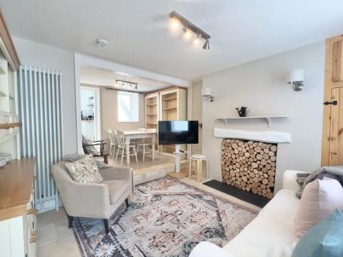 a living room with a couch and a tv at Farthing Cottage…cute ‘n’ cosy! in Kingsbridge