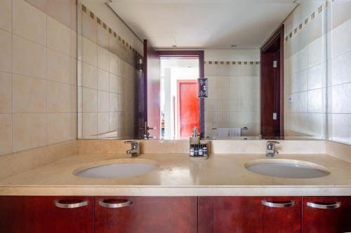 a bathroom with two sinks and a large mirror at Frank Porter - Marina Tower in Dubai