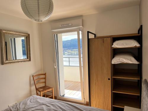 une chambre avec un lit et une porte avec une fenêtre dans l'établissement Appartement Neuf VUE LAC 6/8pers, à Gérardmer