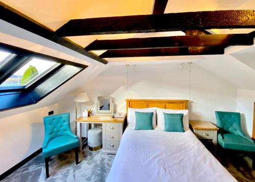 a bedroom with a bed and two blue chairs at Ardlinnhe Bed & Breakfast in Fort William