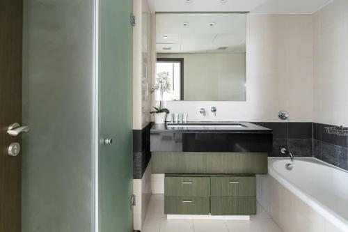 a bathroom with a sink and a tub and a mirror at Frank Porter - The Lofts in Dubai