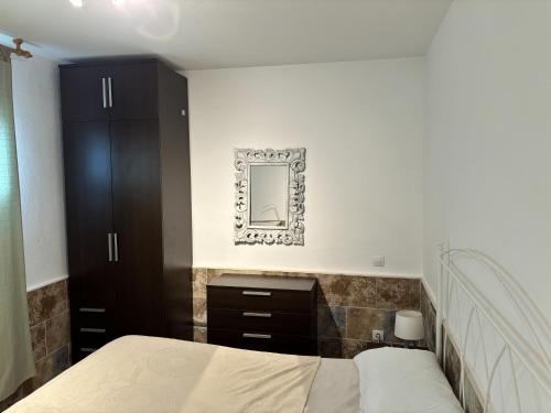 una camera da letto con un letto e uno specchio a parete di Luca's House - 8 minutes from the airport a Costa de Antigua