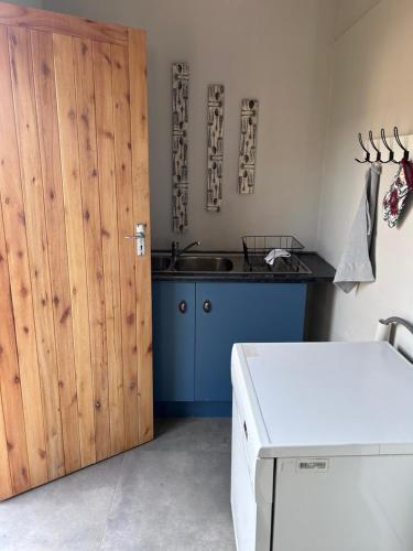 a kitchen with a wooden door and a sink at Lilibeth guesthouse in Parys