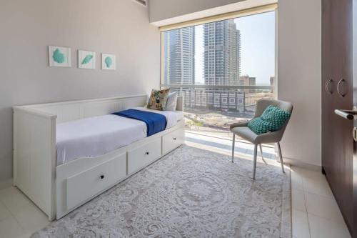 a bedroom with a bed and a chair and a window at Frank Porter - Marina Tower in Dubai