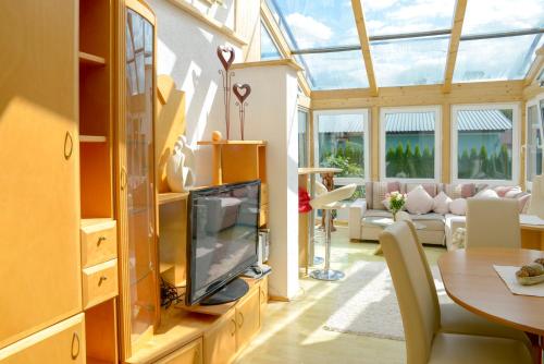 a conservatory with a tv and a living room at Beates Daham in Fohnsdorf