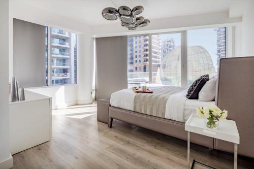a bedroom with a bed and a large window at Frank Porter - Damac Waves in Dubai