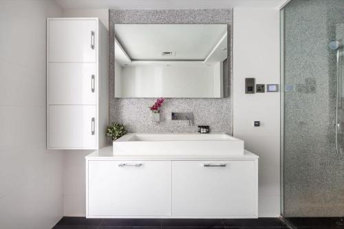 a bathroom with a white sink and a mirror at Frank Porter - Damac Waves in Dubai