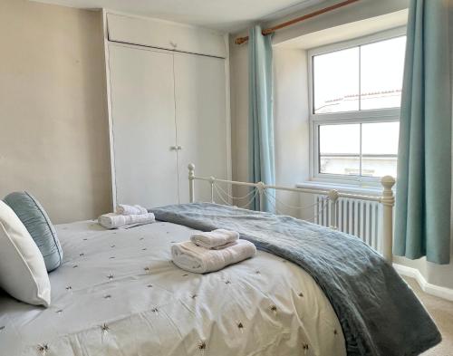 ein Schlafzimmer mit einem großen Bett mit Handtüchern darauf in der Unterkunft Farthing Cottage…cute ‘n’ cosy! in Kingsbridge