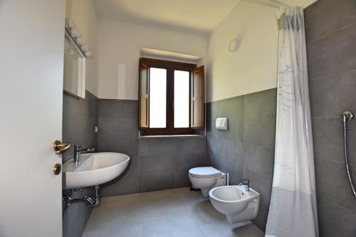La salle de bains est pourvue d'un lavabo, de toilettes et d'une douche. dans l'établissement Borgo Gatteraia, à Volterra