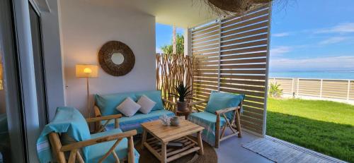 balcón con sofá, sillas y mesa en White Palm, en Paea