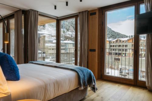 a bedroom with a bed and a large window at ISARD RESIDENCES & SPA by Vip Residences in El Tarter