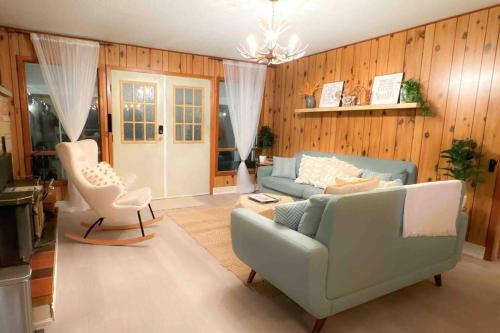 een woonkamer met een bank en een stoel bij Private Riverfront Cottage in Muskoka - The MARA in Huntsville
