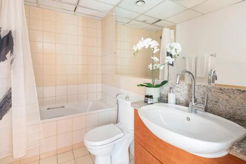 een badkamer met een wastafel, een toilet en een bad bij Frank Porter - Al Samar in Dubai