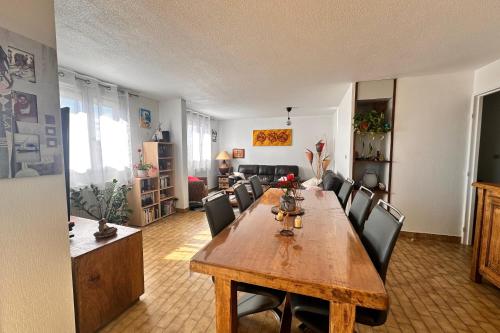 un salon avec une table et des chaises en bois dans l'établissement L'Olivier, au Grau-du-Roi