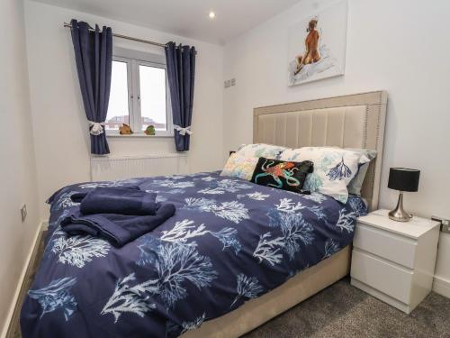 een slaapkamer met een bed met een blauw dekbed bij Wave Song in Hornsea