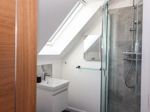 a bathroom with a sink and a shower with a skylight at 8B Carrigreich in Tarbert