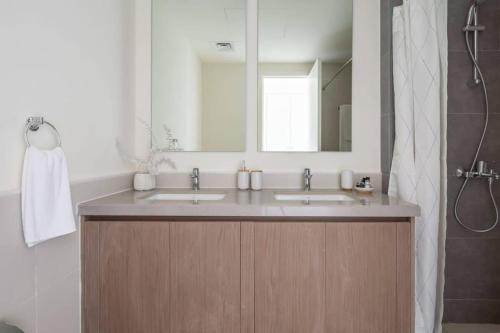 een badkamer met 2 wastafels en een grote spiegel bij Frank Porter - Urbana II in Dubai