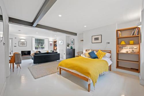 a bedroom with a bed and a living room at Cosy, calm Camden Square studio in London