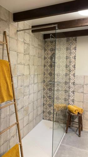 a glass shower in a bathroom with a stool at Finca Valle Verde in Alora