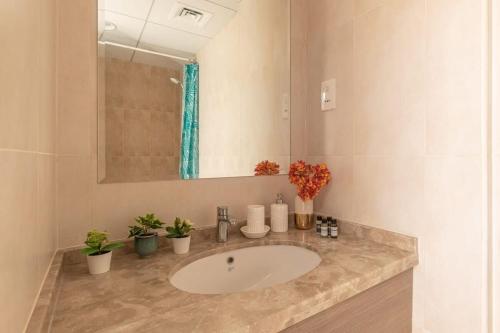 a bathroom with a sink and a mirror and plants at Frank Porter - Canal Residence in Dubai