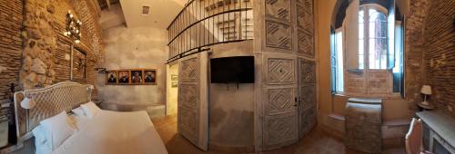 a bedroom with a bed and a tv in a room at Apartamentos Sharis in Jerez de la Frontera