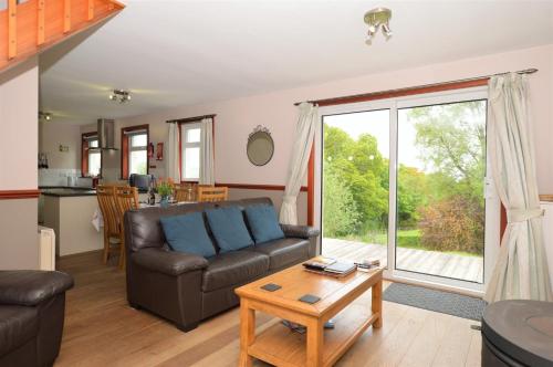ein Wohnzimmer mit Sofa und Tisch in der Unterkunft Rowan Cottage in Blairmore