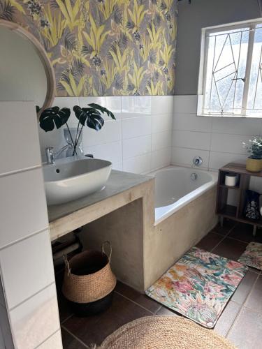 a bathroom with a tub and a sink and a mirror at Lielies Guesthouse in Parys
