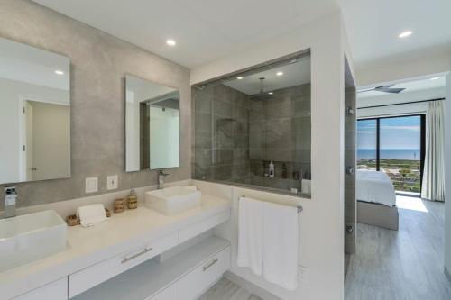 a bathroom with two sinks and a large mirror at Spacious New 3BR Condo at Tramonti plus Resort Access in Cabo San Lucas
