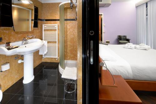 baño con lavabo y cama en Hotel Villa Cansignorio en Lazise