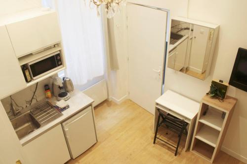 a small kitchen with a sink and a microwave at Cosy love nest near Gare de l'Est in Paris