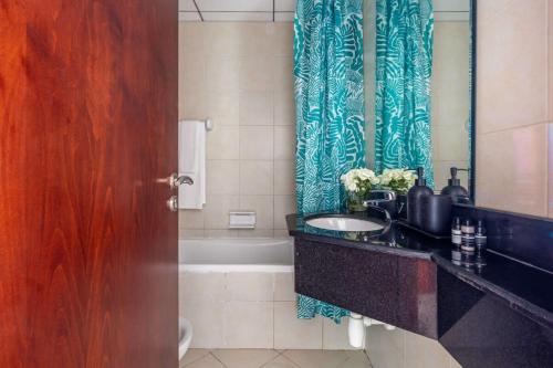 a bathroom with a sink and a shower curtain at Frank Porter - Icon Tower 1 in Dubai