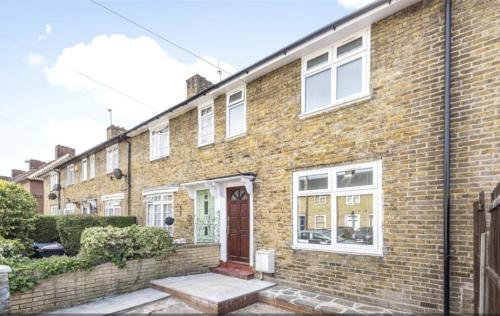 a brick house with a red door and white windows at Fantastic 3-Bedroom House in London in Morden