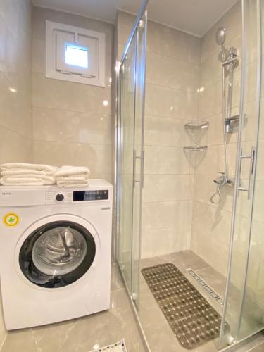 a washing machine in a bathroom with a shower at Brand new cozy 1BDR/1BTH apartment in Bakırköy in Istanbul