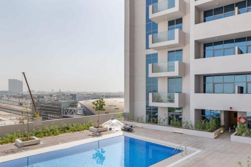 an apartment with a swimming pool and a building at Frank Porter - Azizi Aura in Dubai