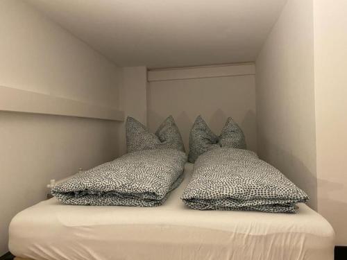 Una cama con cuatro almohadas encima. en Souterrain-Studio - Nähe Burg und Hauptmarkt - Parken, en Núremberg