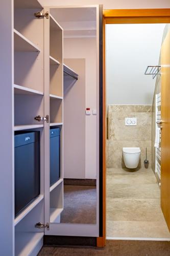 a bathroom with a glass door leading into a bathroom with a toilet at Relax Hotel Stork in Lednice