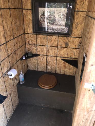 a toilet with a wooden seat in a small room at Blythe Shoals Base Camp in Cleveland