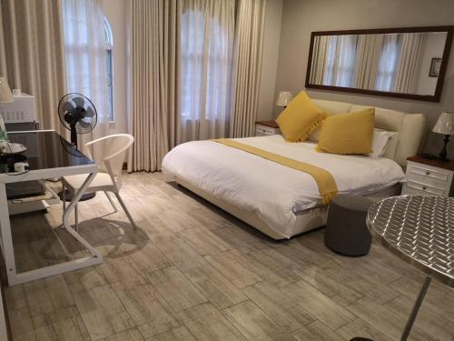 una camera d'albergo con letto e scrivania di Lotus Guest House a Johannesburg