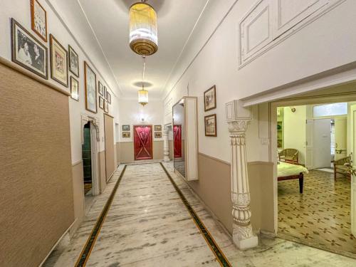a hallway with a column and paintings on the walls at DYORE House by Bharat Mahal Palace in Jaipur
