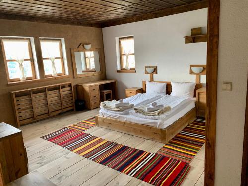 1 dormitorio con 1 cama grande y 1 alfombra en Family Hotel Byalata Kashta en Kovačevica