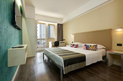 una camera d'albergo con un grande letto e una finestra di Hotel Roma Tor Vergata a Tor Vergata