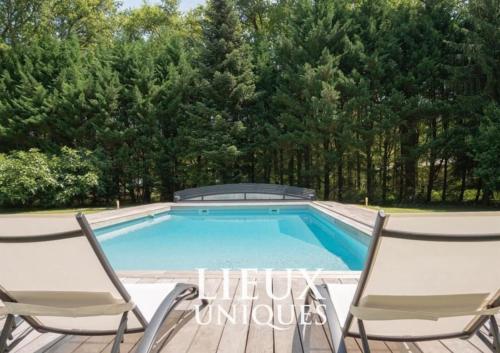 - une piscine avec 2 chaises sur une terrasse dans l'établissement Villa de 4 chambres avec piscine privee jardin clos et wifi a Vouzeron, à Vouzeron