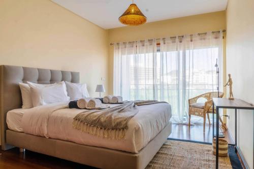 ein Schlafzimmer mit einem großen Bett und einem großen Fenster in der Unterkunft Açor in Ponta Delgada
