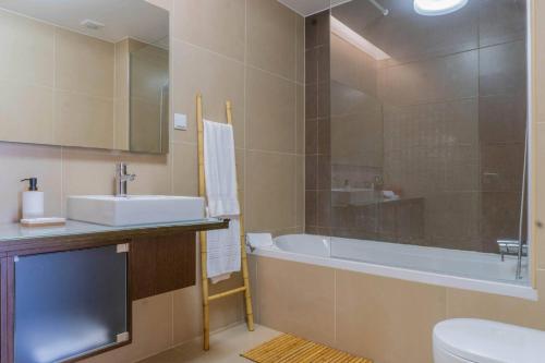 ein Badezimmer mit einer Badewanne, einem Waschbecken und einem WC in der Unterkunft Açor in Ponta Delgada