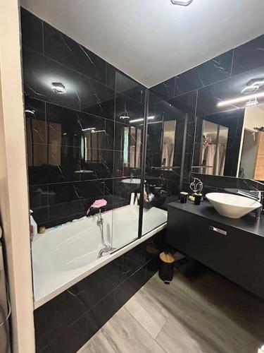 une salle de bain avec une baignoire et un lavabo et une baignoire dans l'établissement Location appartement estivale, à Montagnac